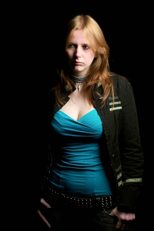 A photo of Kim Onyskiw stood against a black background. Photographer - Joe Bicker